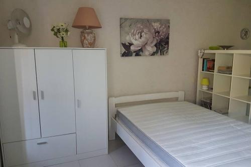 1 dormitorio con 1 cama y armario blanco en Appt 2 étoiles agréable et calme vue sur montagnes, en Amélie-les-Bains-Palalda