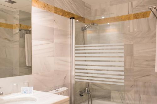ein Bad mit einer Dusche, einem WC und einem Waschbecken in der Unterkunft Sagitario Vista Playa I Apartamentos in Cala Blanca