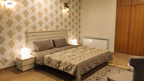 a bedroom with a bed with two lamps on it at Bellevue Luxury Apartments Nathia Gali in Nathia Gali