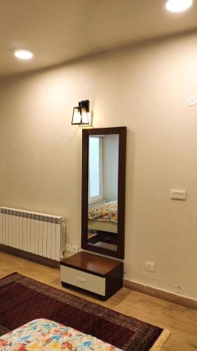 a room with a mirror on the wall and a bed at Bellevue Luxury Apartments Nathia Gali in Nathia Gali