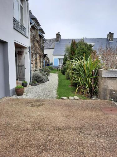 a house with a gravel driveway next to a house at Isles Les Ecrehous in Portbail