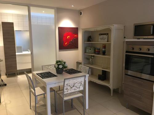 uma cozinha com uma mesa e cadeiras e um micro-ondas em La Suite Alain em Nancy