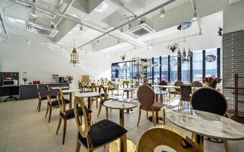 a dining room with tables and chairs and windows at KNox Hotel in Cheonan