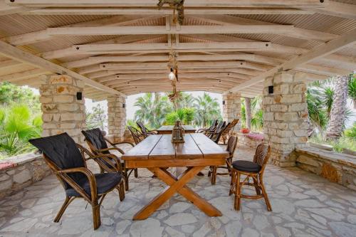 a wooden table and chairs on a patio at ORRAON Lux Aparts K in Preveza