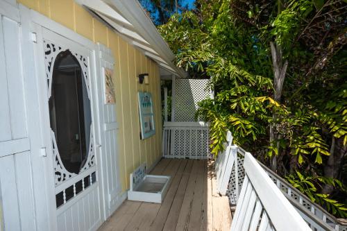 a wooden porch with a white fence and trees at Cedar Cove Resort & Cottages in Holmes Beach