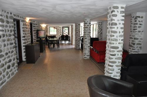 a living room with white brick walls and a couch at Pensiunea Ciobanelu in Malaia