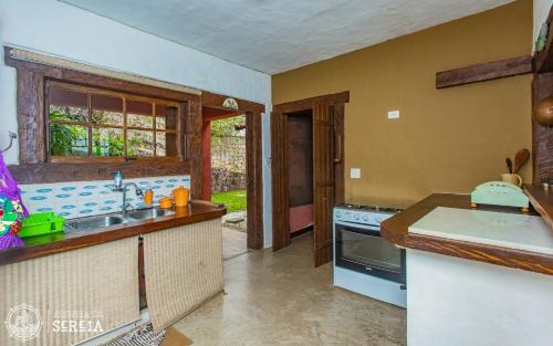 a kitchen with a sink and a stove at Casa Yacht Club in Ilhabela