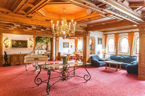 a living room with a table and a piano at Hotel Reiterhof in Wirsberg