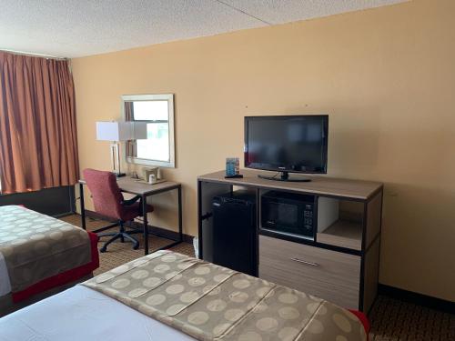 a hotel room with a bed and a flat screen tv at Ramada by Wyndham West Atlantic City in West Atlantic City