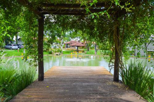 a wooden bridge over a pond with a gazebo at HOTEL ABAPORU in Adamantina