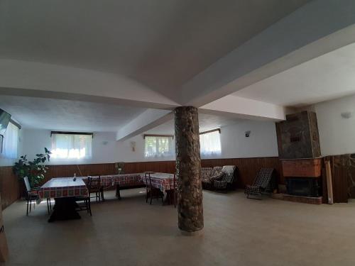 uma grande sala com um pilar e mesas e cadeiras em Pensiunea Casa Transalpina em Sugag