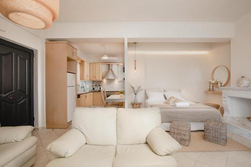 a living room with a white couch and a kitchen at ORRAON Lux Aparts in Preveza