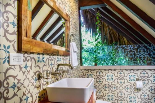 a bathroom with a sink and a window at Cayena by Masaya Collection in Guachaca