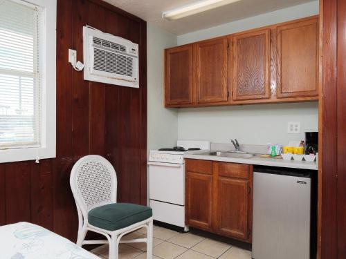 a kitchen with wooden cabinets and a white stove top oven at Sea Aire Oceanfront Inn in Cocoa Beach