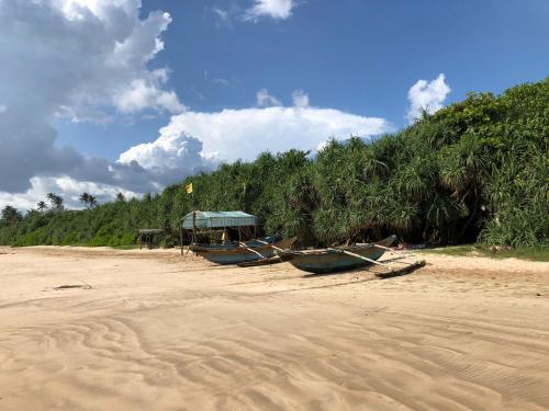 a group of boats sitting on a sandy beach at Villa The Leaf in Weligama