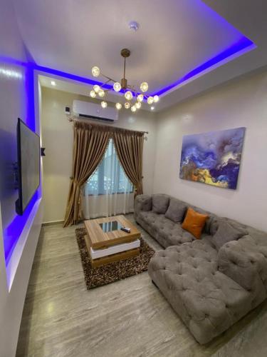 a living room with a couch and a tv at God's Touch Apartments Signature in Lagos