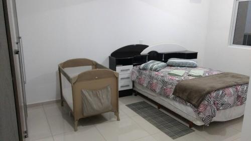 een slaapkamer met een bed, een dressoir en een stoel bij Fabuloso Apto PIRATUBA in Piratuba