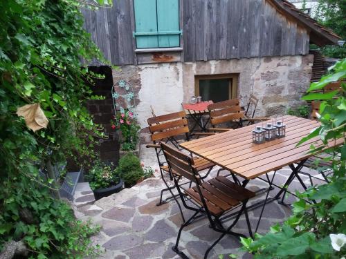a wooden table and chairs on a patio at Meisterhaus Alpirsbach Loft in Alpirsbach