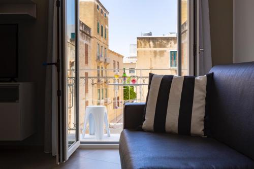 a couch sitting in front of a window at Le Cupole Suites & Apartments in Trapani