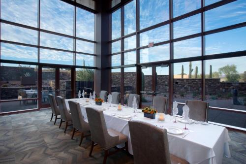 a dining room with tables and chairs and large windows at Wekopa Casino Resort in Fountain Hills