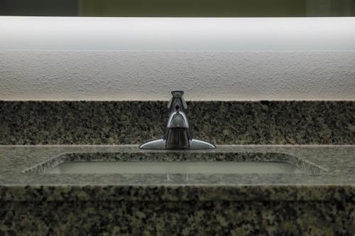 a sink with a faucet in a bathroom at Home Inn and Suites Olive Branch in Olive Branch