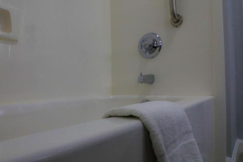 a bathroom with a bath tub with a towel on it at Home Inn and Suites Olive Branch in Olive Branch
