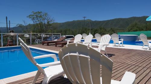 un grupo de sillas sentadas en una terraza junto a una piscina en Complejo M&M en Bialet Massé