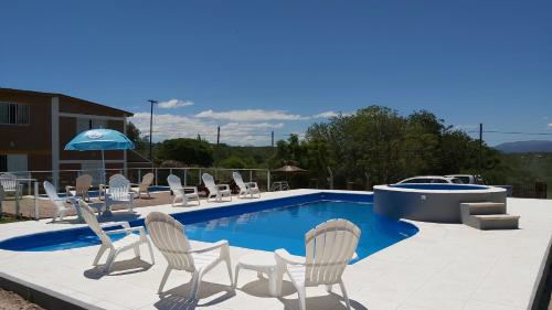 a pool with chairs and a table and a boat at Complejo M&M in Bialet Massé