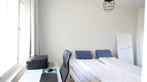 a bedroom with a bed with blue pillows and a table at New one bedroom apartment with TERRACE and Parking in Vantaa