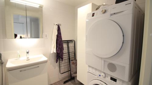 a white bathroom with a sink and a mirror at New one bedroom apartment with TERRACE and Parking in Vantaa