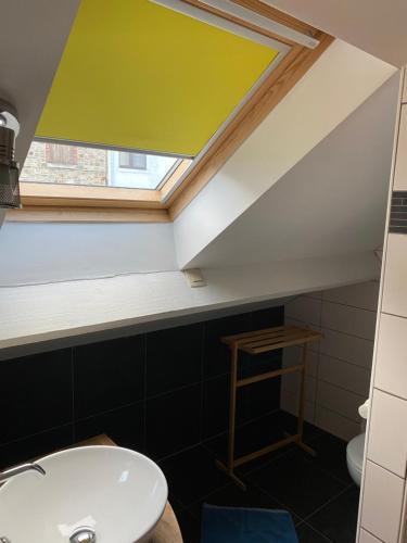 uma casa de banho com um lavatório e uma clarabóia em Chez Mémé em La-Roche-en-Ardenne