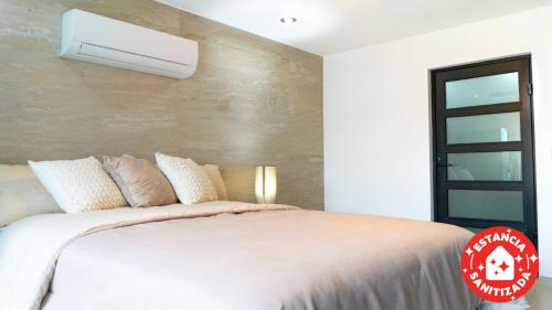 a bedroom with a large white bed with a wall at ECONOSUITES FUNDIDORA in Monterrey