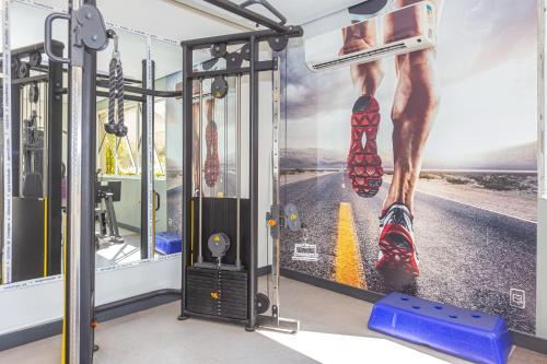a gym with a wall with a picture of a leg in shoes at Mercure Sao Paulo Vila Olimpia in São Paulo