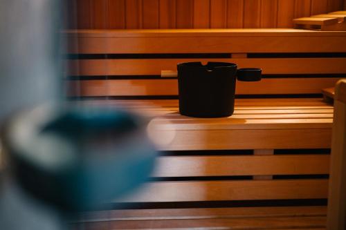 a black trash can sitting on a wooden bench at Moderne 3 Zi.-FeWo BlackForestArt Nähe Freiburg in Simonswald