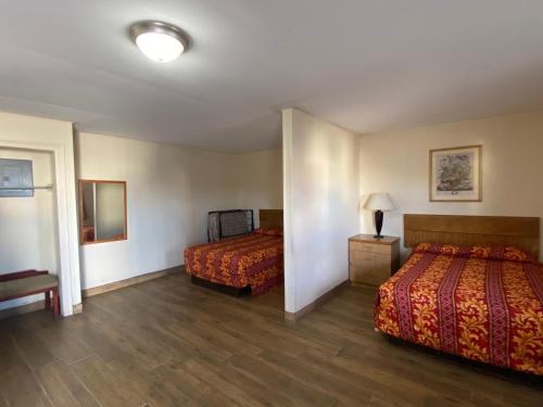 ein Hotelzimmer mit 2 Betten und einem Spiegel in der Unterkunft Relax Inn-Plaquemine in Plaquemine