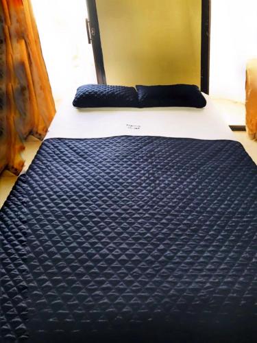 a bed with a blue and white comforter on it at Veranera Hostal in Manta
