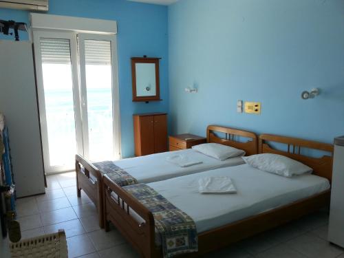 2 Betten in einem Zimmer mit blauen Wänden in der Unterkunft Elena Studios in Tarti