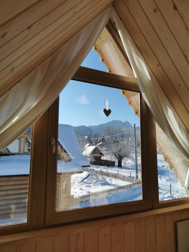 a window in a cabin with a view of the snow at Stylowa Chata in Zakopane