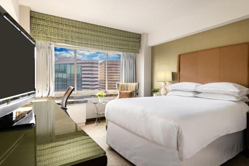 a bedroom with a large bed and a large window at The Stamford Hotel in Stamford