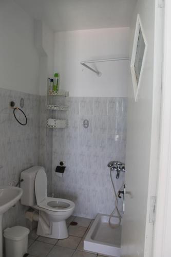a white bathroom with a toilet and a sink at Elena Studios in Tarti
