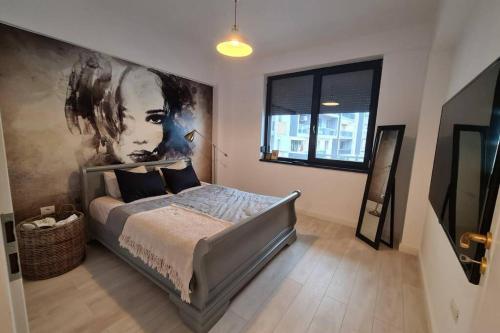 Schlafzimmer mit einem Bett mit Wandgemälde in der Unterkunft Apartament 221 Mamaia Nord in Mamaia Nord – Năvodari