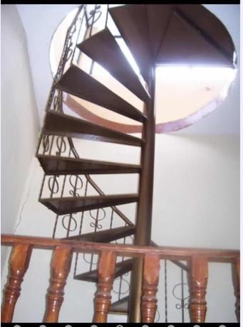 a wooden spiral staircase with a light on the ceiling at Veranera Hostal in Manta
