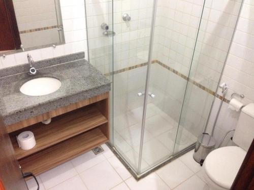 een badkamer met een douche, wastafel en toilet bij Flat Conchas e Corais - Village Paraíso localizado em Taipu de Fora, península de Barra Grande in Barra Grande