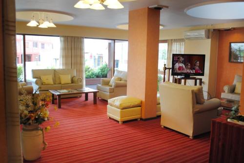 una sala de espera con sofás y sillas en el vestíbulo en Hotel Gran International en Villa Gesell