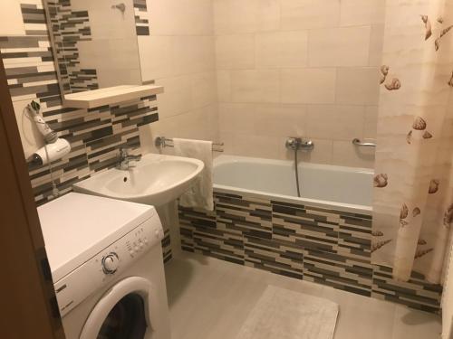 a bathroom with a washing machine and a sink at City Center Apartments Hévíz in Hévíz