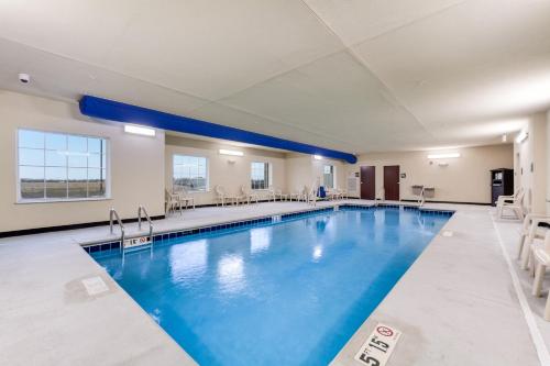 Cobblestone Hotel & Suites - Cozad في Cozad: مسبح كبير مع ماء أزرق في غرفة الفندق