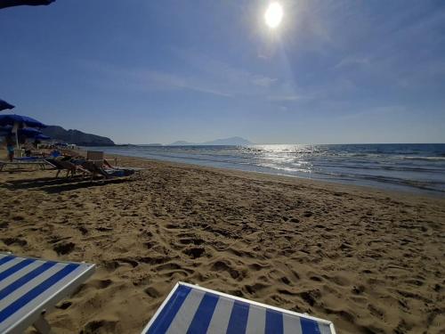 a beach with umbrellas and chairs and the ocean at Rocky & Lia in Bacoli