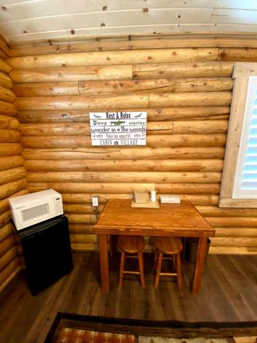 um quarto em madeira com uma mesa e um micro-ondas em Cabin Village em Island Park