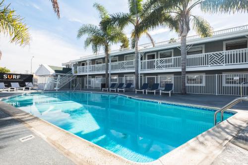 a swimming pool in front of a hotel with palm trees at Beach Haven in San Diego