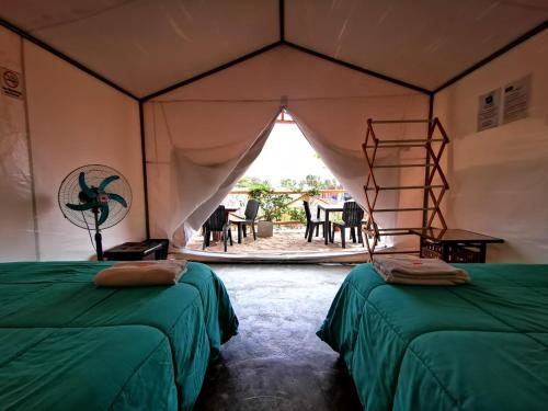 a room with two beds and a table at Ecocamp Huacachina in Ica